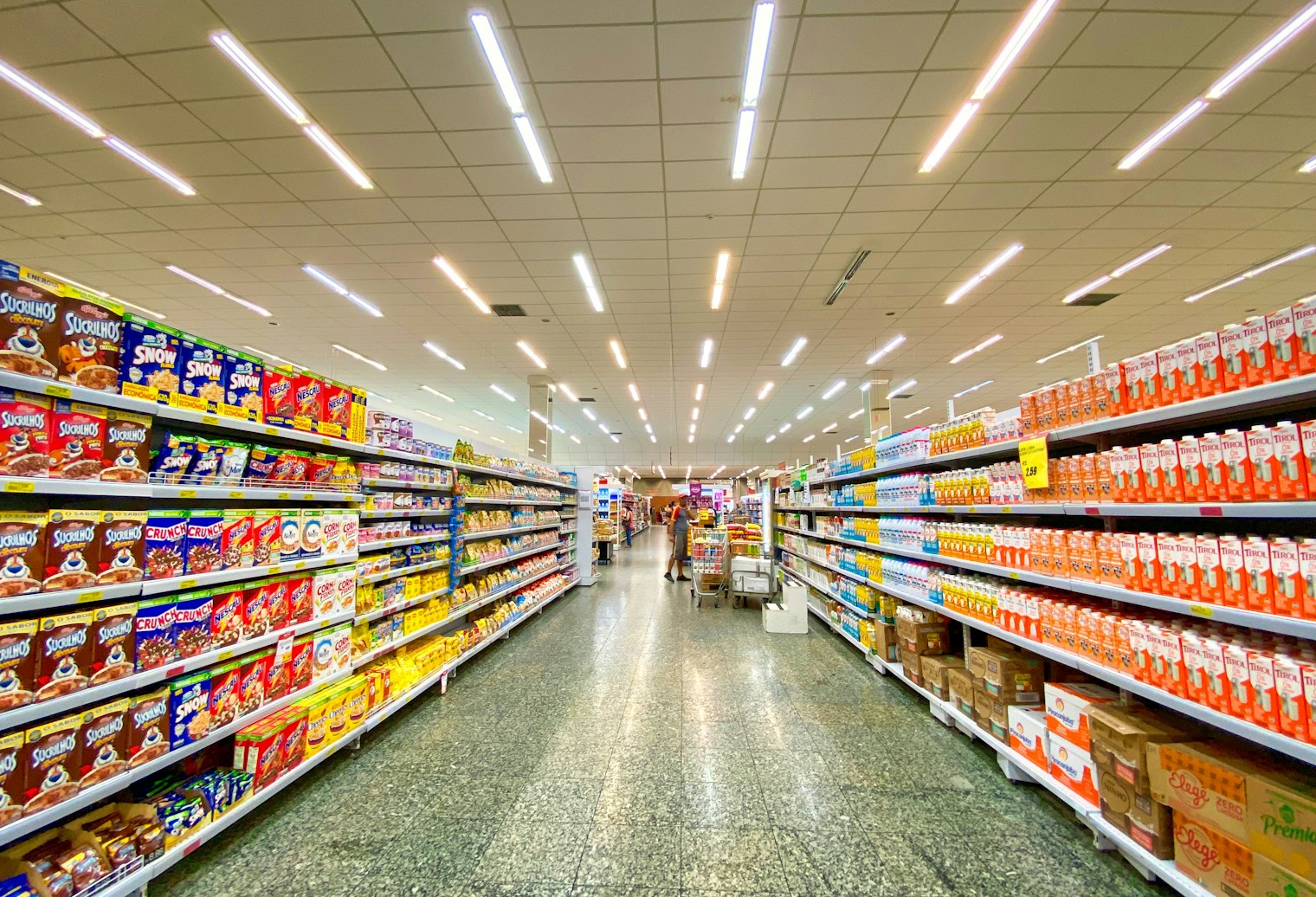 Täyteen lastattu supermarketin käytävä ruoka- ja kodintavaratuotteilla