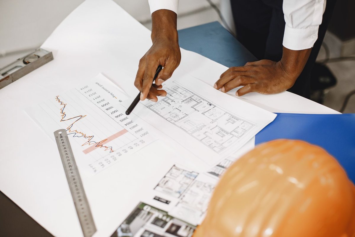 Pointing at a price chart while reviewing project plans